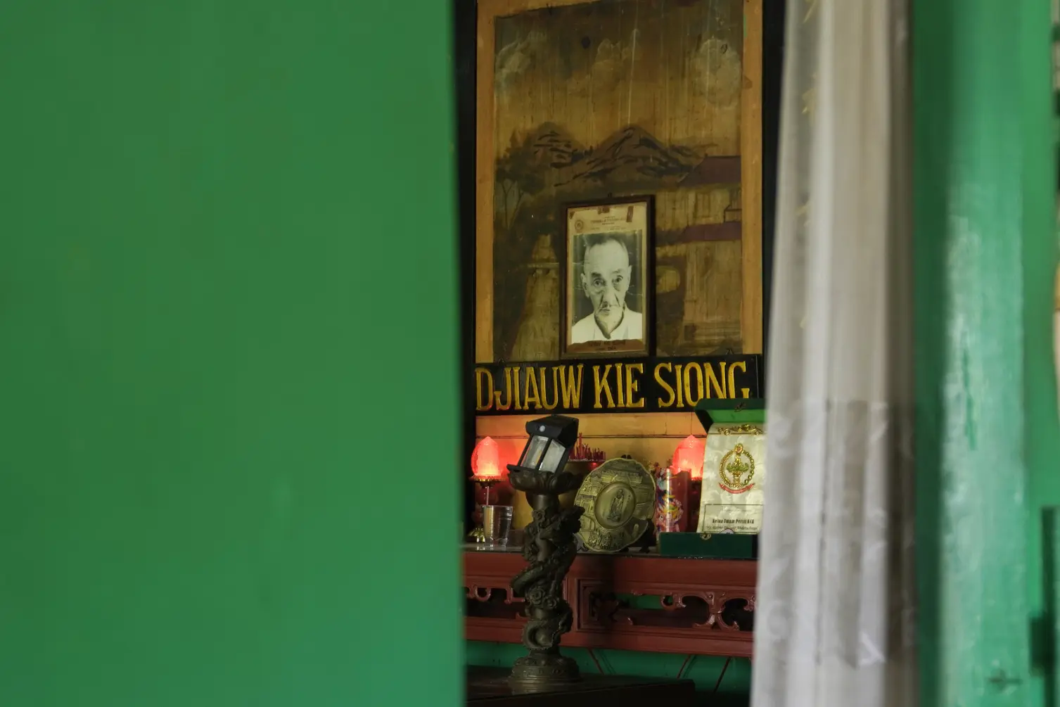 Foto pemilik rumah sejarah Rengasdengklok Djiaw Kie Siong terpajang di ruang tamu.webp