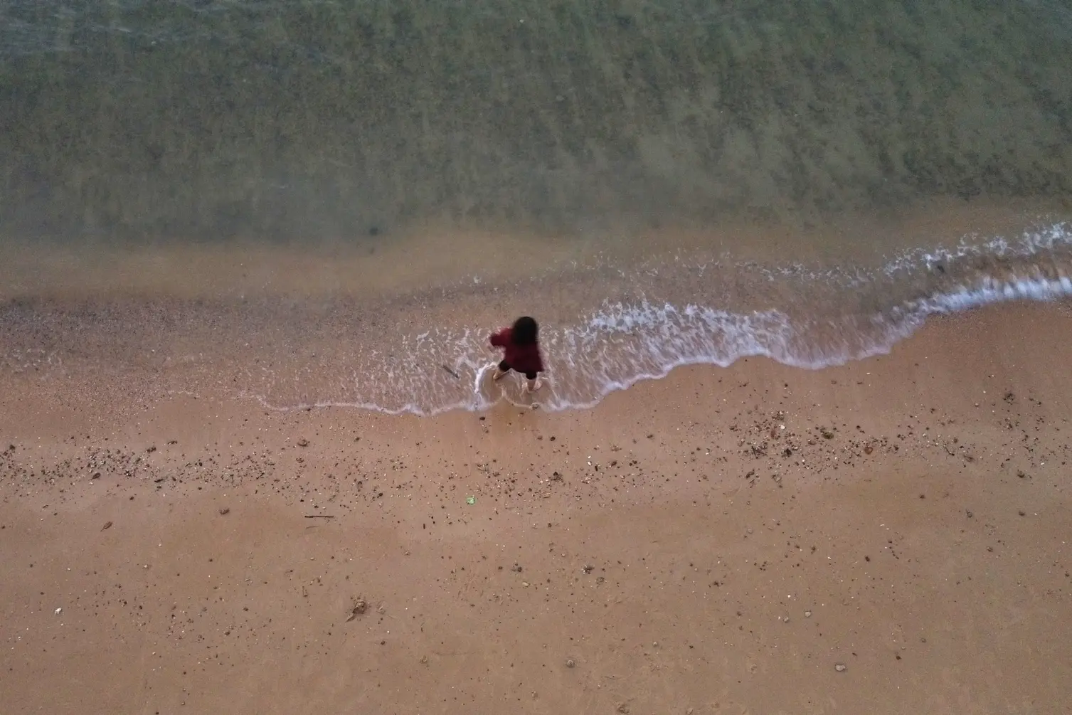 Wisatawan sedang bermain air di tepi pantai Tanjung Layar Batam.webp