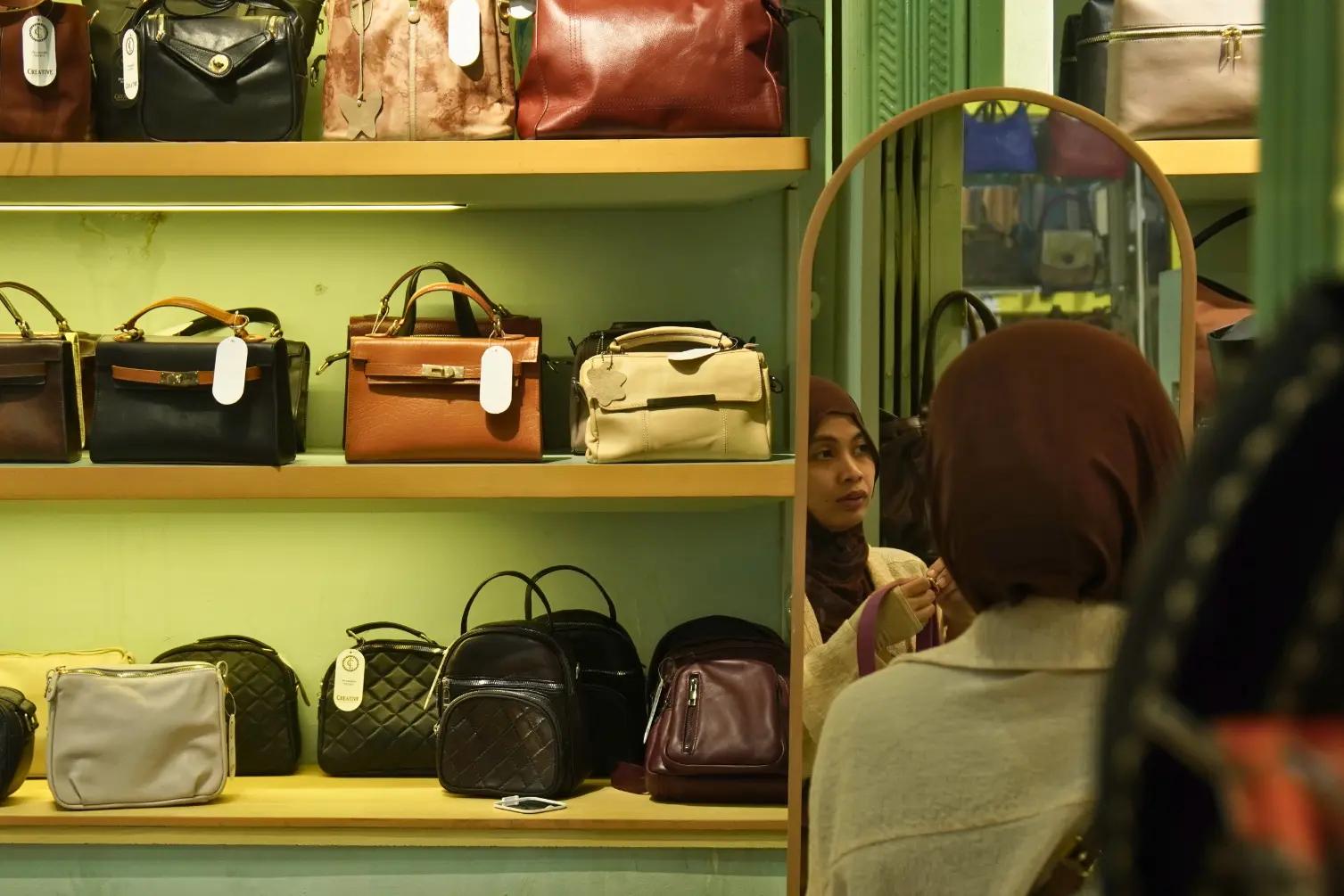 Pengunjung wanita sedang mencoba produk tas kulit di Sentra Kulit Sukaregang, Garut